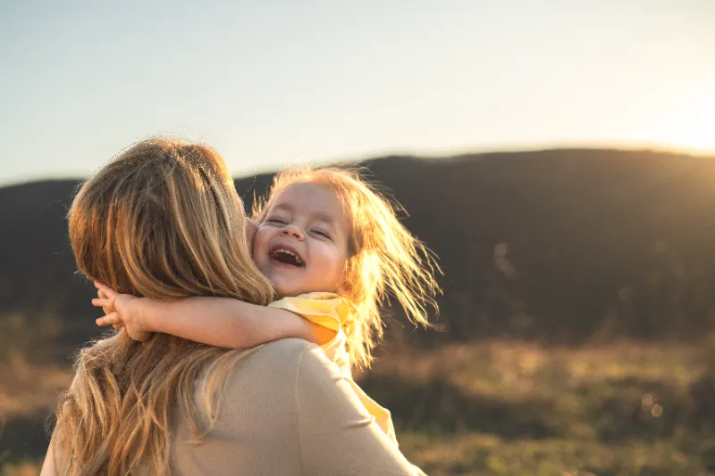 Mother embracing young child outdoors after custody hearing in Colorado.